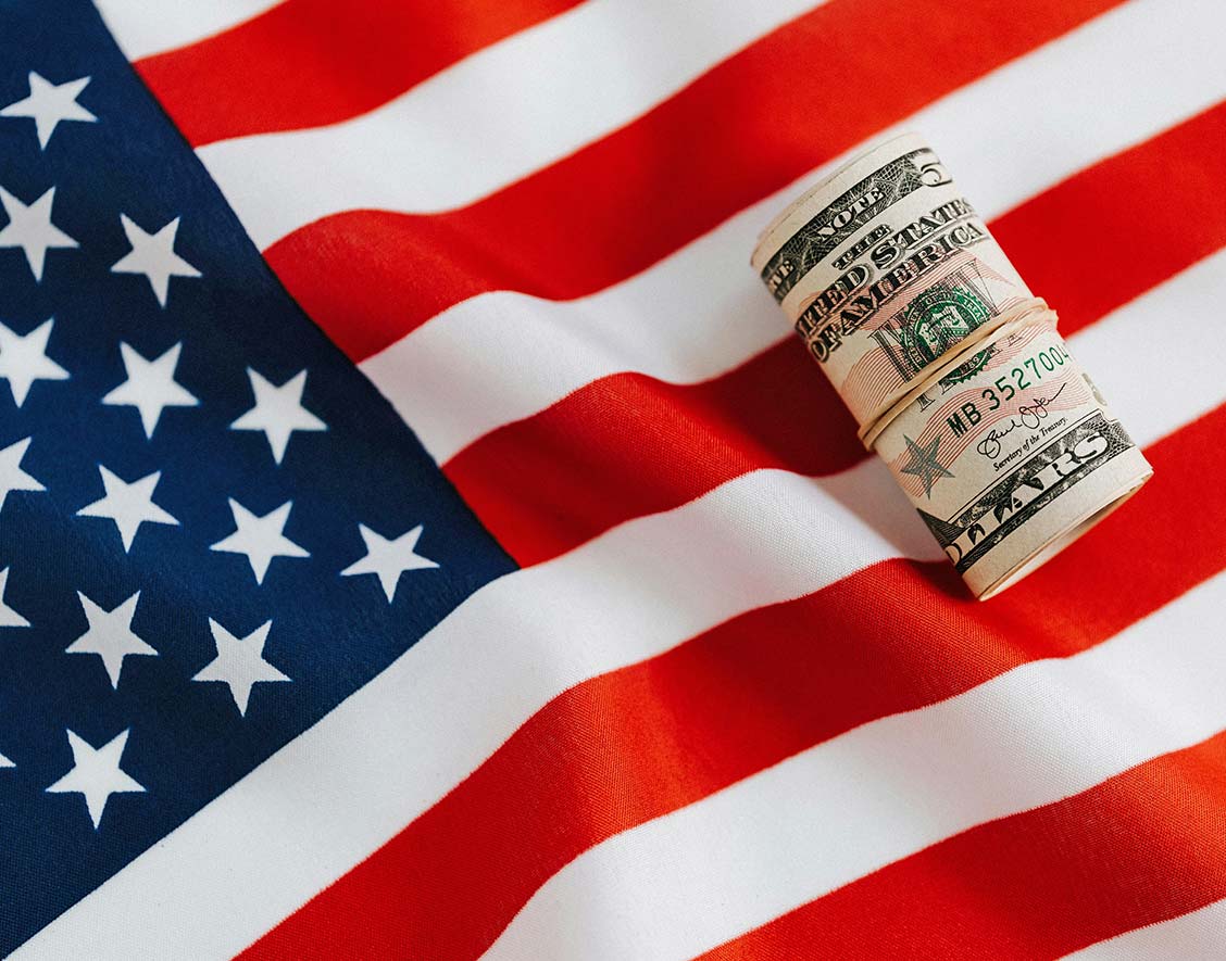 Roll of Dollar Bills on American Flag Roll of Dollar Bills on American Flag